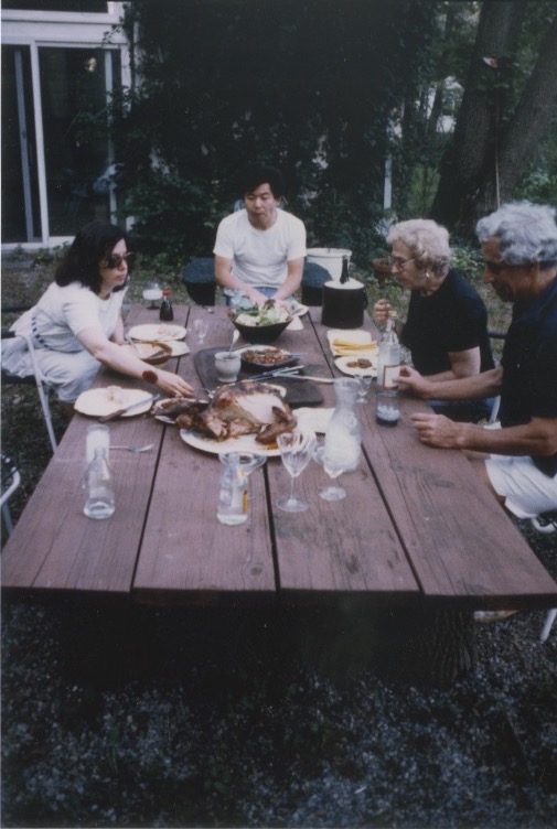 Arakawa and Madeline eating turkey with her parents at a picnic table